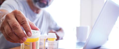 Man reaching out to prescription bottle