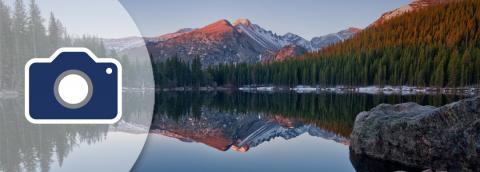 camera icon over serene mountain lake scene banner