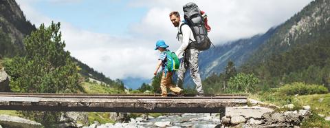 man hiking with young boy in mountains