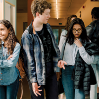 photo of diverse students in school hallway talking between classes