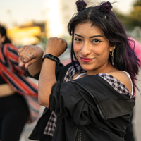 photo of a group of hispanic teens dancing hip hop with the focus on a female with a mischievous smile