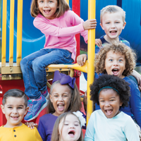 photo of a diverse group of seven elementary age children on school playground equipment
