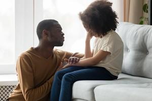 Man comforting small child on couch